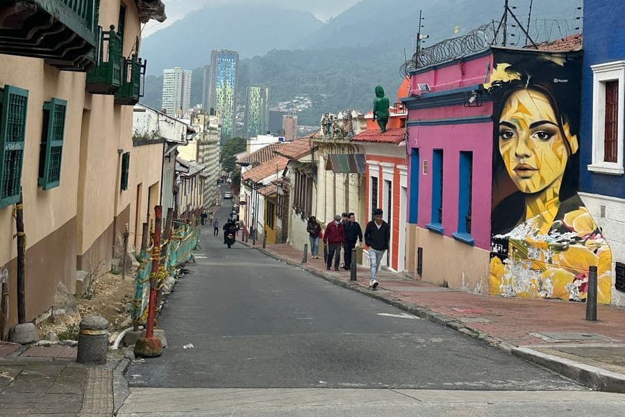 A steep residential street descending through a Colombian hillside.