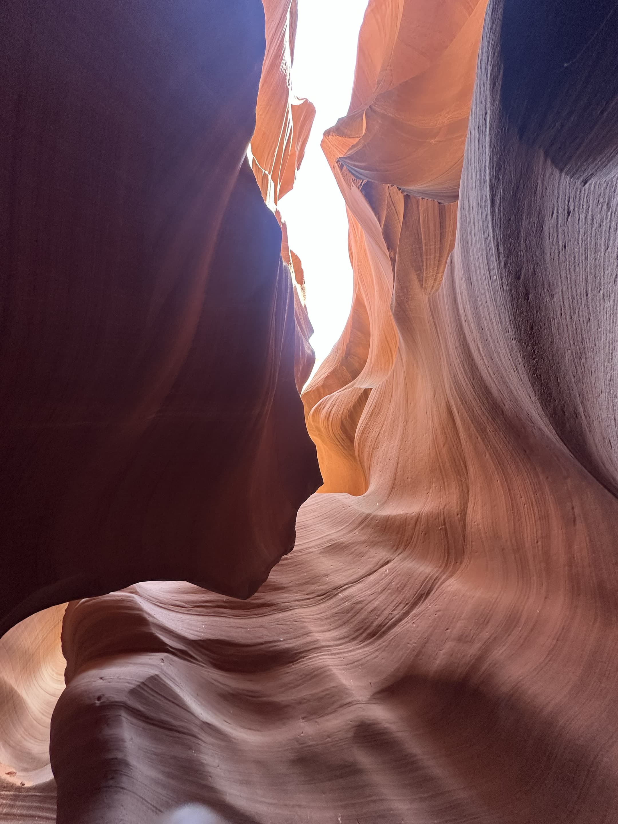 Sunlight cutting through the sculpted walls of a slot canyon.